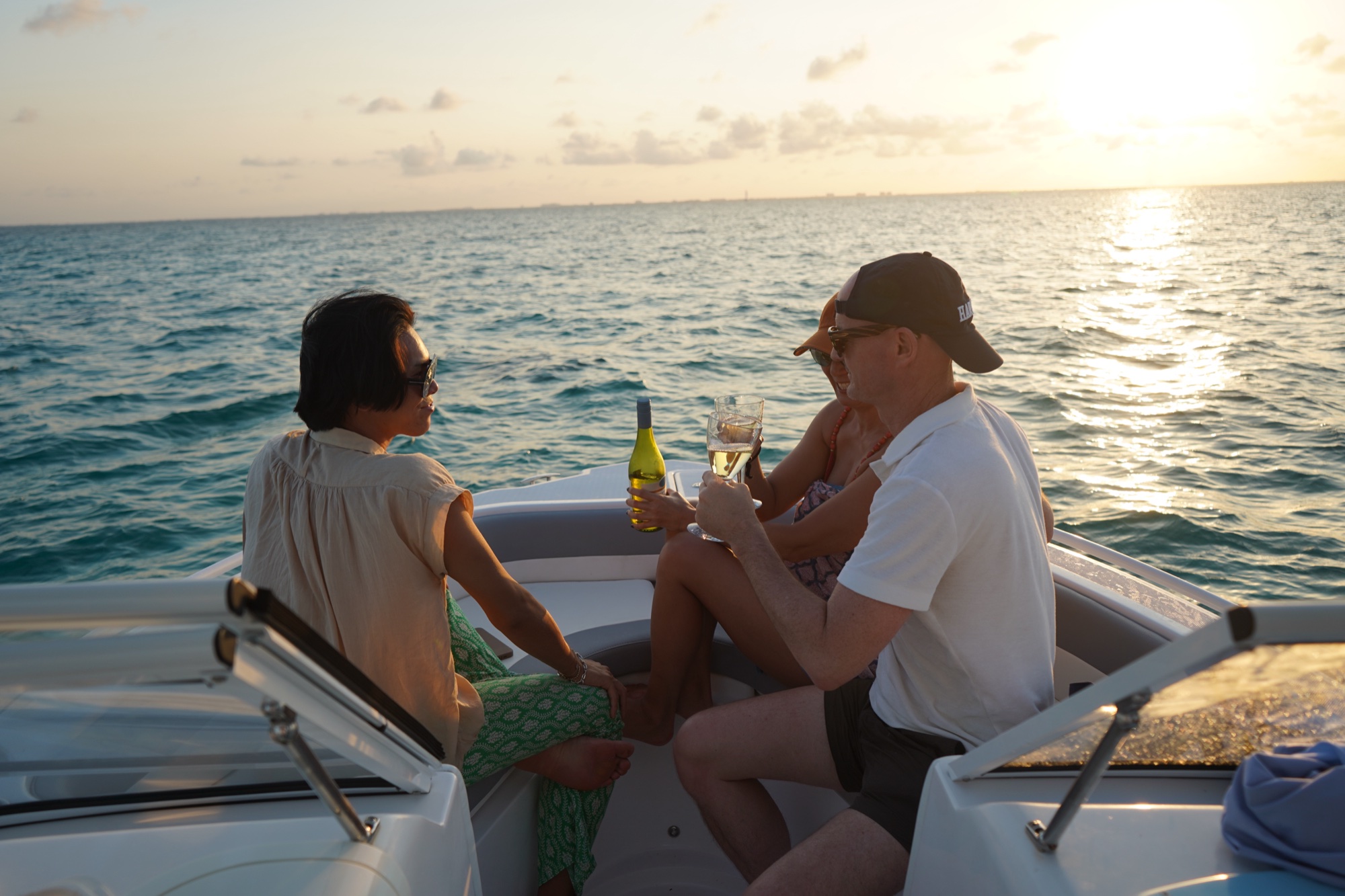 Guests toasting at sunset aboard the charter boat, Grand Cayman