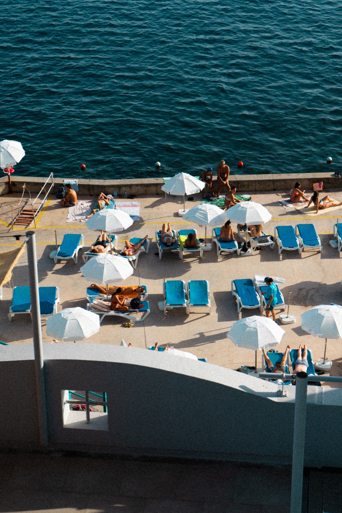 Aerial view of a hotel pool deck with umbrellas and sunbeds, Madeira, Portugal